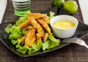 chicken nuggets sau fasii de piept de pui pane LCHF cu faina de migdale si seminte de susan, cu sos de curry si lime