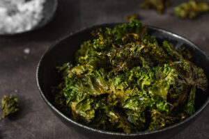 kale chips with salt in a black bowl