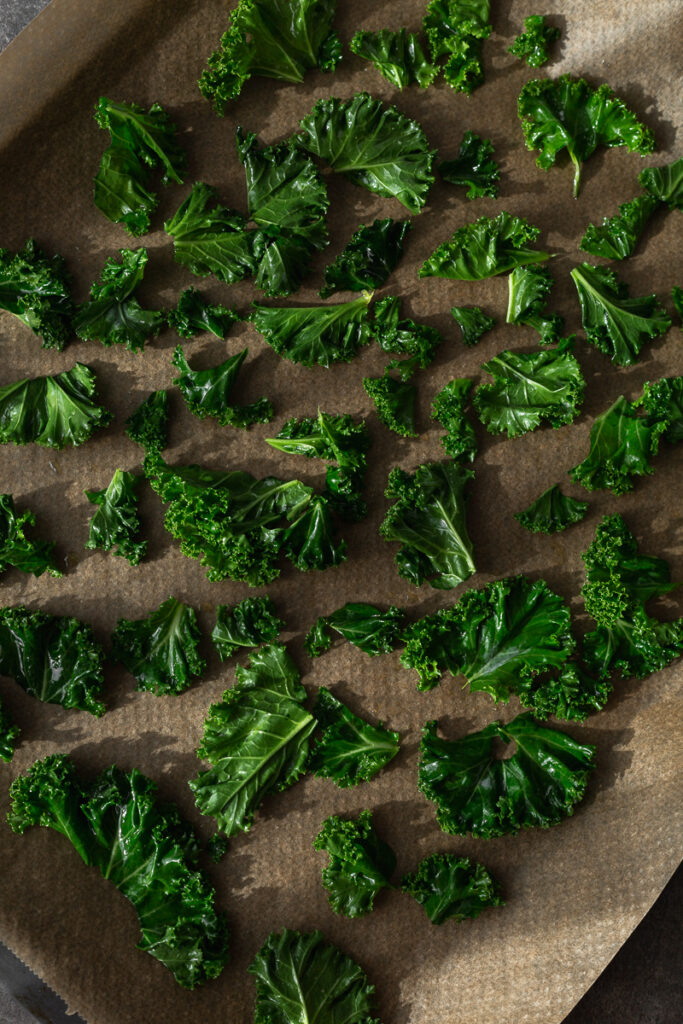 kale chips on a baking sheet, cut in small pieces