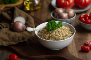 Romanian aubergine caviar in a bowl served on a rustic table with onions and tomatoes