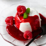 panna cotta din lapte de cocos si coulis de zmeura pe farfurie cu zmeura proaspata si frunze de menta