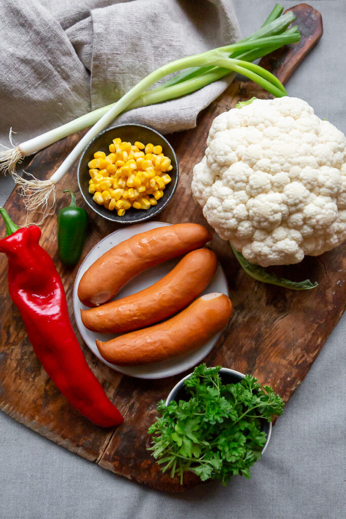 ingrediente pentru orez mexican din conopida cu chorizo, pe un fund de lemn