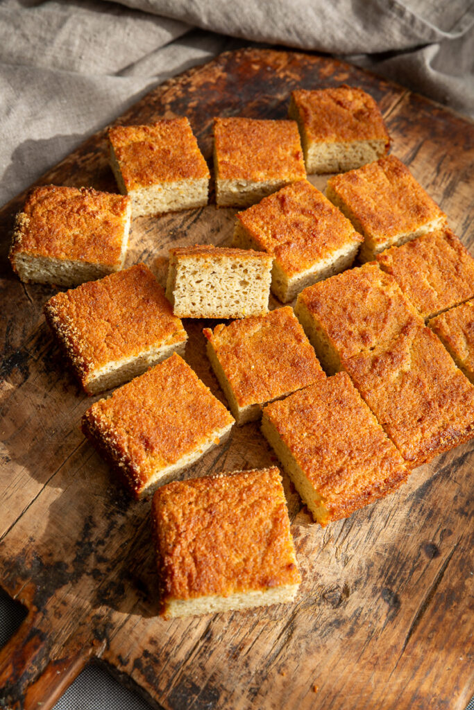 prajitura cu iaurt keto taiata in patrate pe un fund de lemn rustic