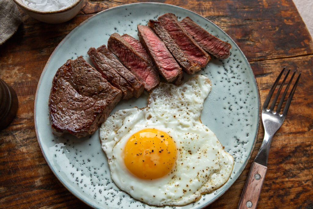 Steak and Eggs keto – friptura felii cu oua pe o farfurie