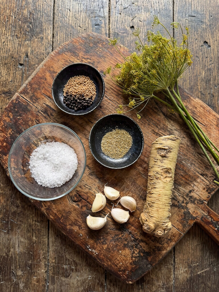 Ingrediente pentru castraveti murati in saramurape un fund de lemn